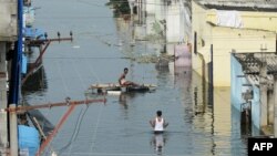 FILE - Flood-affected residents search for their belongings following heavy rains on the outskirts of Hyderabad, India, Oct. 20, 2020.