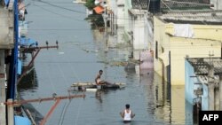 Flood-affected residents search for their belongings following heavy rains on the outskirts of Hyderabad, India.