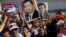 Supporters of former Egyptian President Hosni Mubarak hold his posters and a poster of Egyptian Army Chief Lt. Gen. Abdel-Fattah el-Sissi, left, in front of Tora prison in Cairo, Aug. 22, 2013.