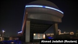 People sit in their cars watching a movie in a drive-in cinema at the Mall of the Emirates, following the outbreak of the coronavirus disease (COVID-19), in Dubai, United Arab Emirates, May 13, 2020. (REUTERS/Ahmed Jadallah)