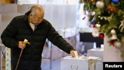 A man casts his ballot in a lower-house parliamentary election in Tokyo, Dec. 14, 2014.