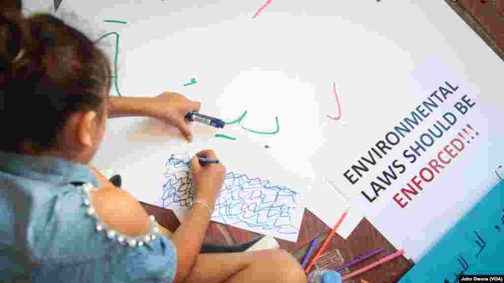 A child takes part in protests against the disposal of waste into the sea.