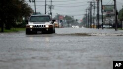 Une voiture conduit dans une rue inondée au Lac Charles, le 27 août 2017.