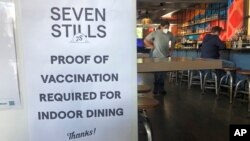 A proof of vaccination sign is posted at a bar in San Francisco on Thursday, July 29, 2021. Until now, many employers had taken a passive approach relying outreach and incentives. But that has been shifting, with vaccine mandates gaining momentum. (AP Photo/Haven Daley)
