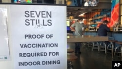 Tanda bukti vaksinasi dipasang di sebuah bar di San Francisco pada Kamis, 29 Juli 2021. (Foto: AP)