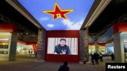  A visitor watches a video showing Chinese President Xi Jinping at a military meeting during an exhibition displaying China's achievements for the past five years, as a part of the celebrations of the upcoming 19th National Congress of the Communist Party of China.