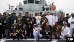 FILE - Foreign naval officers group up for a photo on the naval training ship Qi Jiguang before a celebration to remember the 70th anniversary of the founding of China's PLA Navy April 23, 2019. (Photo by Mark Schiefelbein / POOL / AFP)