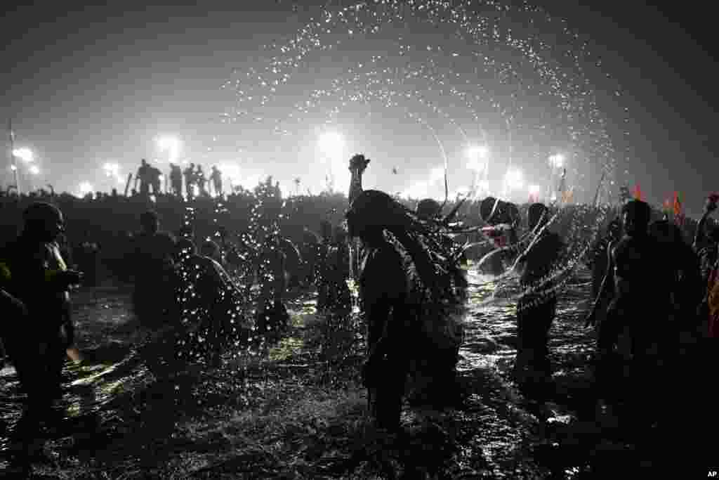 Naga Sadhus or Hindu holy men take dips at Sangam, the confluence of three sacred rivers the Yamuna, the Ganges and the mythical Saraswati, on Vasant Panchami during the Kumbh Mela in Prayagraj, Uttar Pradesh state, India.