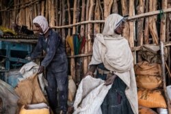 People process sorghum in a mill, in a rural area near the village of Dabat, 70 kilometres northeast from the city of Gondar, Ethiopia, on July 13, 2021.