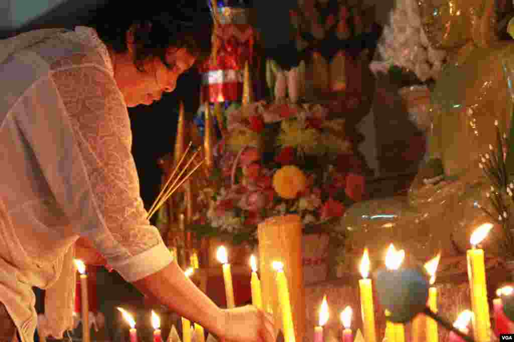 ពុទ្ធបរិស័ទ្ធអុជធូបនិងទៀនឧទ្ទិសកុសលដល់ព្រលឹងជីដូនជីតាមុនបោះបាយបិណ្ឌ។ (ឡេង ឡែន/VOA)