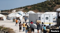 Refugees and migrants from the destroyed Moria camp enter a new temporary camp on the island of Lesbos, Greece, Sept. 20, 2020. 