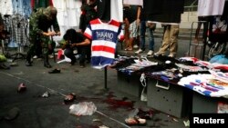 A Thai soldier photographs the crime scene following a bomb blast in Bangkok Feb. 23, 2014.
