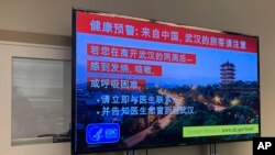 지난 21일 미국 시애틀 공항에 설치된 모니터 화면에 우한 폐렴 의심 증상 발생 시 대처 요령에 관한 중국어 안내문이 나오고 있다.