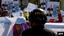 រូបឯកសារ៖ ប៉ូលិសឃ្លាំមើលសកម្មភាពតវ៉ារបស់បុគ្គលិកក្រុមហ៊ុនណាហ្គាវើលដ៍ដើម្បីទាមទារឲ្យក្រុមហ៊ុនទទួលយកបុគ្គលិកដែលត្រូវបានបញ្ឈប់ពីការងារកាលពីឆ្នាំមុនចូលធ្វើការងារវិញ នៅមុខអគាររដ្ឋសភាជាតិ នៅរាជធានីភ្នំពេញ កាលពីថ្ងៃទី ៤ ខែមករា ឆ្នាំ ២០២២។ 