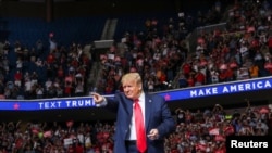 FILE - President Donald Trump points at the crowd as he enters his first re-election campaign rally in several months in the midst of the coronavirus disease outbreak, at the BOK Center in Tulsa, Okla., June 20, 2020. 