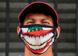 A street vendor wearing a face mask poses outside the central market in San Salvador on May 6, 2020, amid the COVID-19 coronavirus pandemic. (Photo by Yuri CORTEZ / AFP)