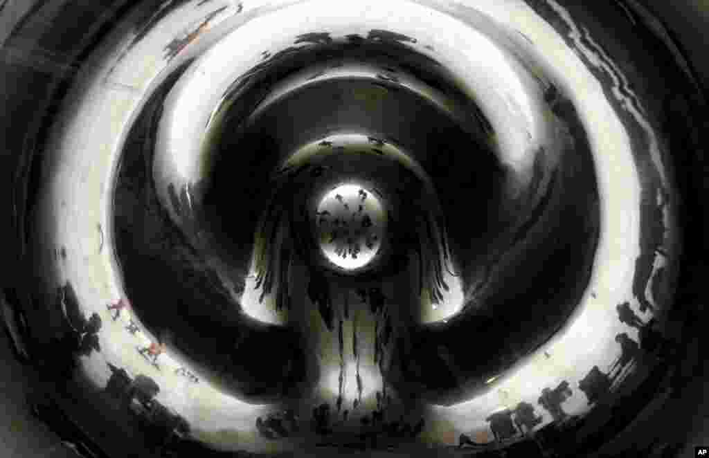 Warga menikmati suasana di taman Millennium di kota Chicago, AS yang diselimuti oleh salju.