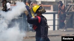 Učesnik protesta u Karakasu baca suzavac tokom demonstracija protiv aktuelnog predsednika Nikolasa Madura (Foto: Reuters) 