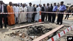 Nigerian President Goodluck Jonathan (C, with black hat) visits St. Theresa's Catholic church, the scene of a Christmas day bomb attack, just outside the capital Abuja, December 31, 2011.