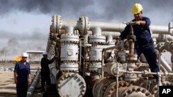 FILE - Iraqi workers at the Rumaila oil refinery, near Basra, 340 miles (550 kilometers) southeast of Baghdad, Iraq.