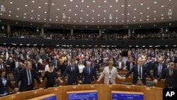 MEP's sing and hold hands after a vote on the UK's withdrawal from the EU, the final legislative step in the Brexit proceedings, during the plenary session at the European Parliament in Brussels, Jan. 29, 2020. 
