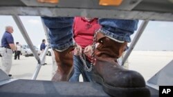 ពលរដ្ឋ​ម៉ិកស៊ិក​ដែល​ដាក់​ច្រវ៉ាក់​នៅ​នឹង​ជើង​ឡើង​យន្តហោះ​របស់​ទីភ្នាក់ងារ​អន្តោប្រវេសន៍ និង​ការ​អនុវត្ត​ច្បាប់​គយ​សហរដ្ឋ​អាមេរិក សម្រាប់​ការ​ចាប់​បញ្ជូន​ខ្លួន​ទៅ​មាតុភូមិ​វិញ នៅ​ព្រលាន​យន្តហោះ​អន្តរជាតិ O'Hare នៅ​ក្នុង​ក្រុង Chicago រដ្ឋ Illinois កាលពី​ថ្ងៃទី២៥ ខែ​ឧសភា ឆ្នាំ២០១០។