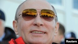 Russian President Vladimir Putin watches the cross country skiing men's relay during the Olympic Winter Games in Sochi Feb. 16, 2014.
