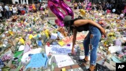 A young woman views of flower tributes for the victims of Monday's explosion at St Ann's square in central Manchester, England, May 25 2017.
