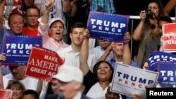 People cheer as Republican presidential nominee Donald Trump speaks on a stage during a campaign event in Dimondale, Mich., Aug. 19, 2016.