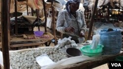 A woman sells odowa stones at a roadside market in Nairobi, Kenya (R. Ombuor/VOA).