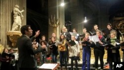 In this photo taken Monday, Dec. 16, 2019, Notre Dame cathedral choir's director Henri Chalet directs the Notre Dame choir during a rehearsal at the Saint Sulpice church in Paris. (AP Photo/Michel Euler)