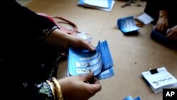 An Afghan election worker counts ballots at a polling station in Jalalabad, east of Kabul, Afghanistan, June 14, 2014. 