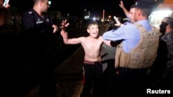 Iraqi security forces detain a boy after removing a suicide vest from him in Kirkuk, Iraq, Aug. 21, 2016.