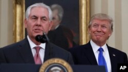 Presiden AS Donald Trump tersenyum saat mendampingi Menteri Luar Negeri Rex Tillerson yang baru dilantik di Gedung Putih (1/2). (AP/Carolyn Kaster)