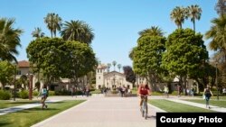 Students pass by the Mission Santa Clara de Asís at Santa Clara University.