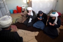 FILE- Jailed Taliban members pray inside the Pul-e-Charkhi prison in Kabul, Afghanistan, Dec. 14, 2019.