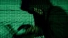 FILE - A man holds a laptop computer as cyber code is projected on him in this illustration picture taken on May 13, 2017. 