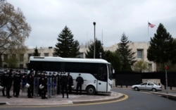 Riot police are stationed nearby as U.S. soldiers stand guard on the rooftop of the U.S. embassy during a protest against a statement made by U.S. President Joe Biden, in Ankara, Turkey, April 26, 2021.