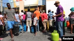 People gather while waiting to buy gas in Port-au-Prince, Haiti, Feb. 16, 2019. 