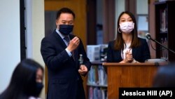 In this Monday, May 10, 2021 photo, Conn. Attorney General William Tong, left and teacher Clarissa Tan, right, listens as a student asks a question during a program for Asian Pacific American Heritage Month at Farmington High School in Farmington, Conn. (AP Photo/Jessica Hill)