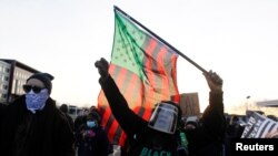 FILE - Protesters march near the Brooklyn Center Police Department, as protests continue after former police officer Kim Potter fatally shot Daunte Wright, in Brooklyn Center, Minnesota, April 16, 2021. 