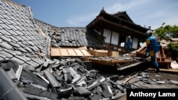 A rescue team searchs damaged houses for trapped people in Mashiki, Kumamoto prefecture, southern Japan, April 15, 2016.