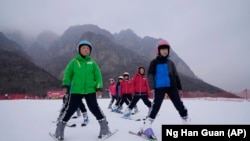 School children learning to ski take to the hills at the Vanke Shijinglong Ski Resort in Yanqing outside of Beijing, China on December. 23, 2021. (AP Photo/Ng Han Guan)