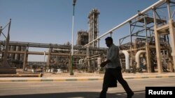 FILE - A man walks past the Mahshahr petrochemical plant in Khuzestan province, southwest of Tehran, Iran.