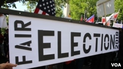 ពលរដ្ឋ​ខ្មែរ​អាមេរិកាំង​មក​ពី​បណ្តា​រដ្ឋនានា​នៅ​ជុំវិញ​សហរដ្ឋ​អាមេរិក មក​ជួបជុំ​គ្នា​ធ្វើ​បាតុកម្ម​តវ៉ា​ឲ្យ​មាន​ការ​គោរព​សិទ្ធិមនុស្ស និង​លិទ្ធិ​ប្រជាធិបតេយ្យ ​នៅ​កម្ពុជា នៅ​មុខ​ក្រសួង​ការបរទេស រដ្ឋធានី​វ៉ាស៊ីនតោន កាលពី​ថ្ងៃទី១៥ ខែកញ្ញា ឆ្នាំ២០១៧។ (សាយ ​មុន្នី/VOA)