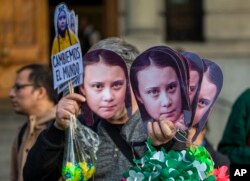 A man sells Greta Thunberg masks during a climate protest rally in Santiago, Chile, Sept. 27, 2019.
