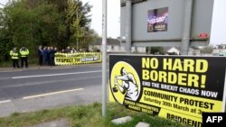 Protesters against Brexit and the possible imposition of any hard border between Northern Ireland and Ireland gather with a banner at the border between Derry (Londonderry) in Northern Ireland and County Donegal in the Republic of Ireland near the Irish v