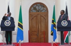 FILE - Tanzania's President John Magufuli, flanked by Kenya's President Uhuru Kenyatta, addresses a news conference during his official visit to Nairobi, Kenya, Oct. 31, 2016.