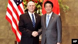 Le vice-président américain Mike Pence serre la main au Premier ministre japonais Shinzo Abe à Tokyo, le 7 février 2018.