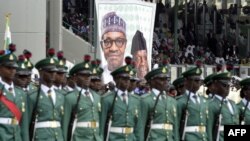 Des soldats nigérians devant un poster du président Mohammadu Buhari, à Abuja, le 29 mai 2015. (AFP PHOTO/PIUS UTOMI EKPEI)